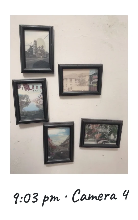 Camera 4, 9:03 pm: framed old photographs of town streets on a white wall