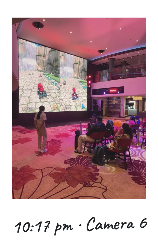 Camera 6, 10:17 pm: two large screens showing a racing game, with guests watching from armchairs